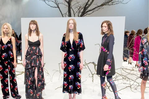 Trees form a backdrop to a fashion presentation.