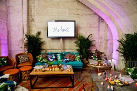 Potted palms frame a colorful lounge beneath a vaulted ceiling.