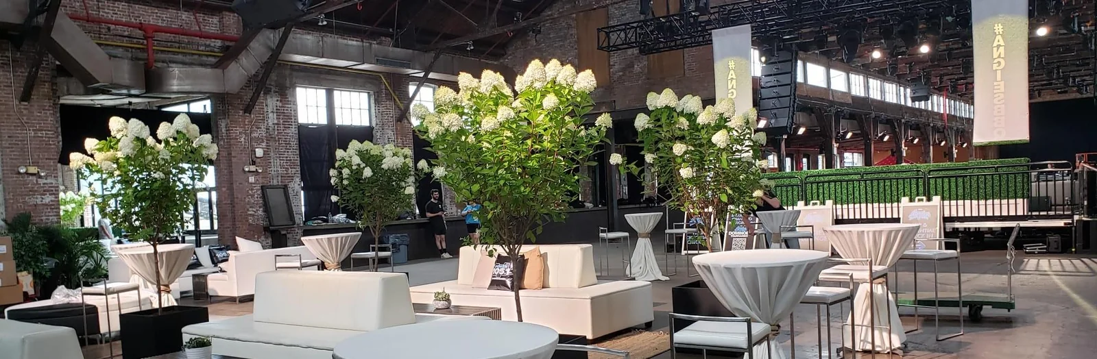 Orchids, hedge dividers, and lounge seating across a large event venue.